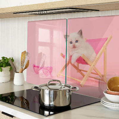 Planche à découper verre Un chaton sur une chaise longue sur fond rose