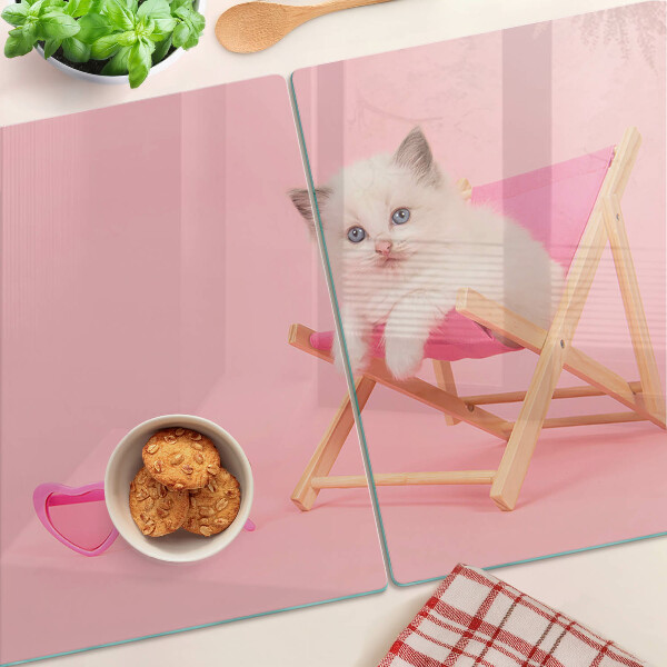 Planche à découper verre Un chaton sur une chaise longue sur fond rose