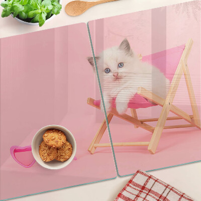 Planche à découper verre Un chaton sur une chaise longue sur fond rose
