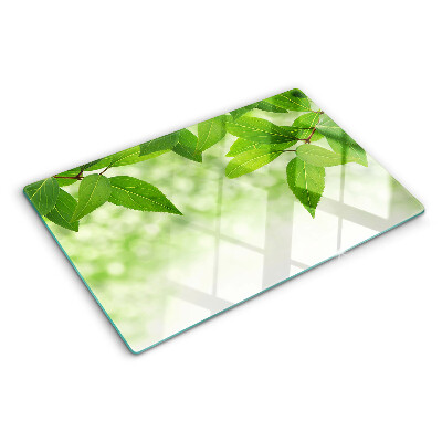 Planche à découper en verre Feuilles sur fond de verdure floue