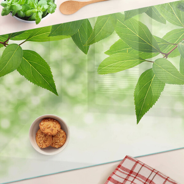 Planche à découper en verre Feuilles sur fond de verdure floue