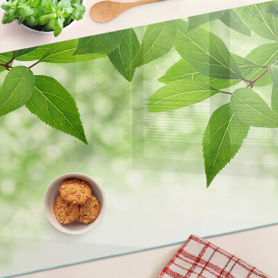 Planche à découper en verre Feuilles sur fond de verdure floue