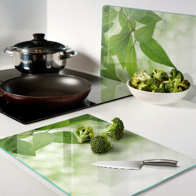 Planche à découper en verre Feuilles sur fond de verdure floue