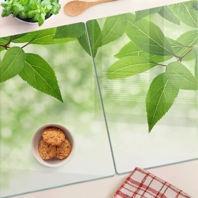 Planche à découper en verre Feuilles sur fond de verdure floue