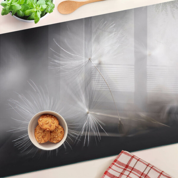 Planche à découper en verre Pissenlits duveteux sur fond de fenêtre