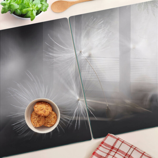 Planche à découper en verre Pissenlits duveteux sur fond de fenêtre