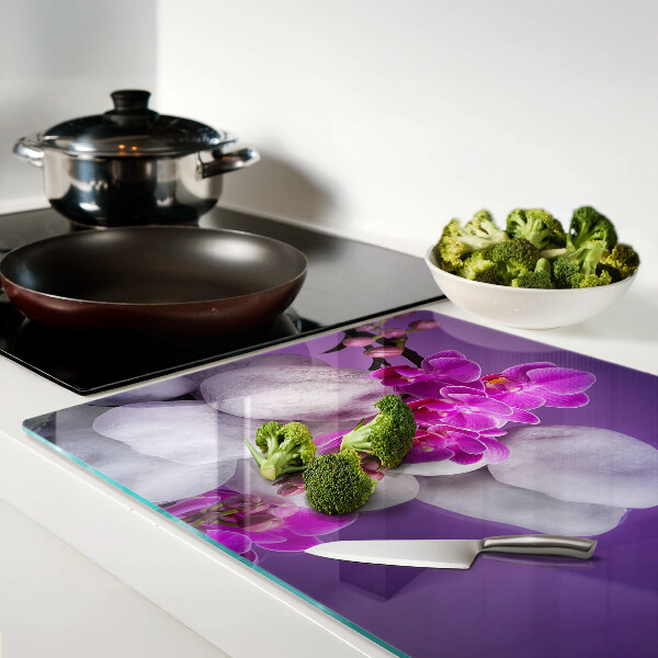 Planche à découper verre Fleurs d'orchidées sur fond de pierres