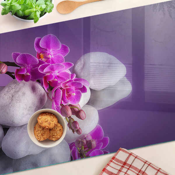 Planche à découper verre Fleurs d'orchidées sur fond de pierres