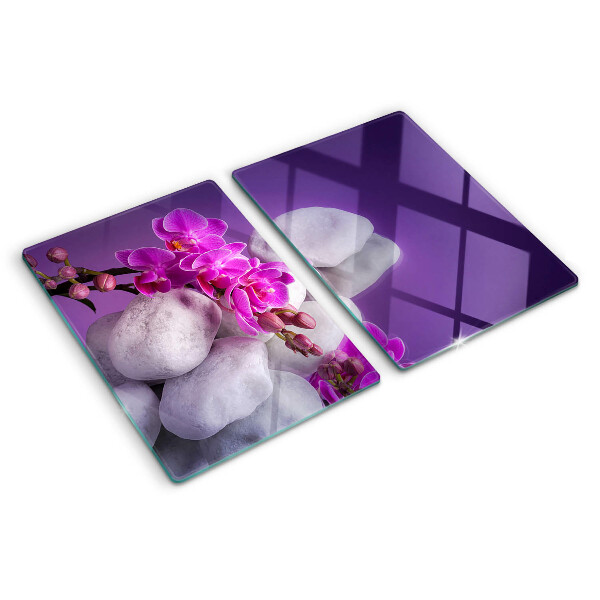 Planche à découper verre Fleurs d'orchidées sur fond de pierres
