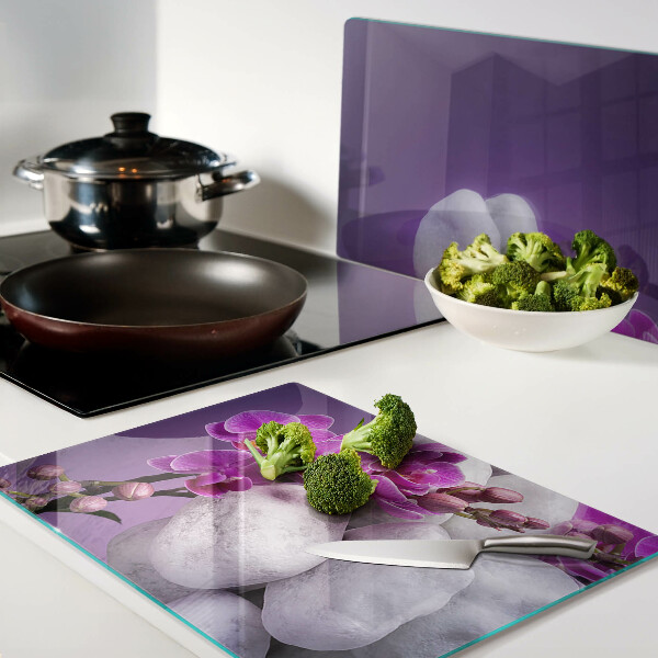 Planche à découper verre Fleurs d'orchidées sur fond de pierres