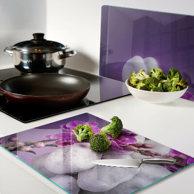 Planche à découper verre Fleurs d'orchidées sur fond de pierres