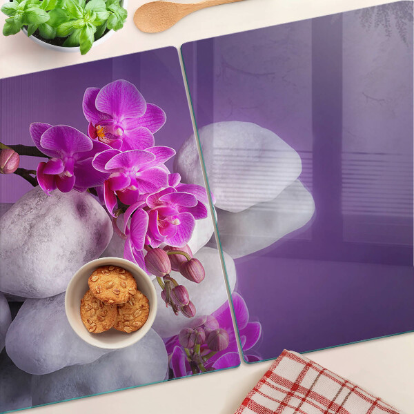 Planche à découper verre Fleurs d'orchidées sur fond de pierres