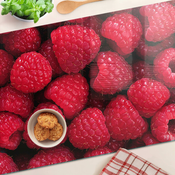 Planche à découper verre Des framboises en arrière-plan