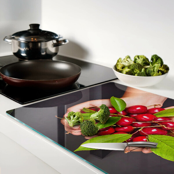 Planche à découper verre Cerises rouges dans les mains