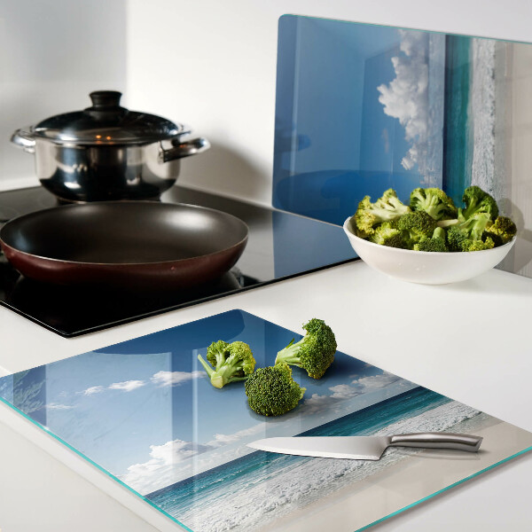 Planche à découper en verre Une plage avec de l'eau turquoise et des nuages