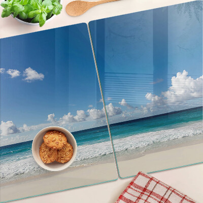 Planche à découper en verre Une plage avec de l'eau turquoise et des nuages