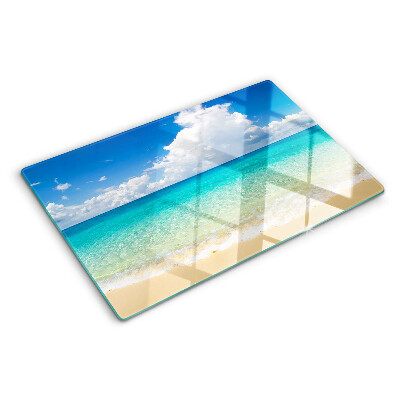 Planche à découper en verre Une plage avec de l'eau turquoise et des nuages