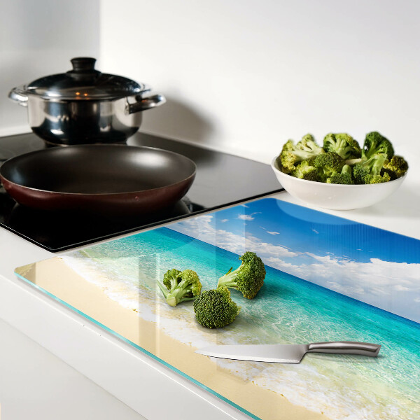 Planche à découper en verre Une plage avec de l'eau turquoise et des nuages
