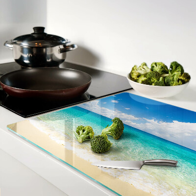Planche à découper en verre Une plage avec de l'eau turquoise et des nuages