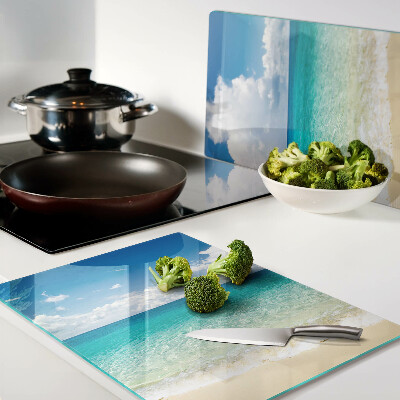 Planche à découper en verre Une plage avec de l'eau turquoise et des nuages