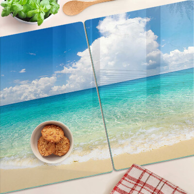 Planche à découper en verre Une plage avec de l'eau turquoise et des nuages