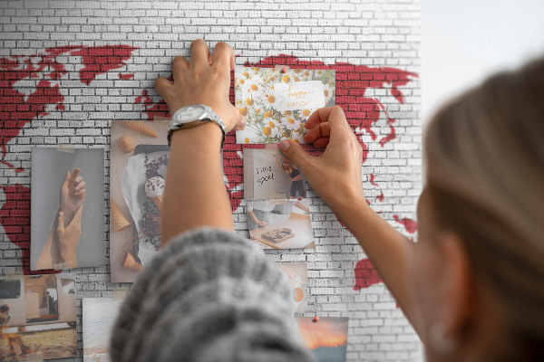 Tableau affichage liège Contour rouge du monde sur un mur de briques