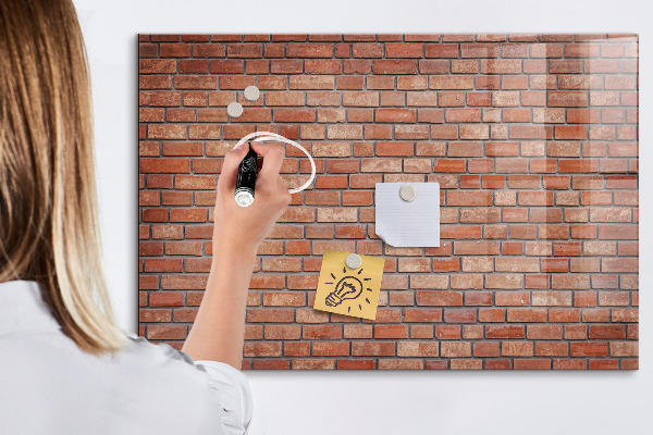 Tableau magnétique effaçable Un tableau d'affichage sur un mur de briques