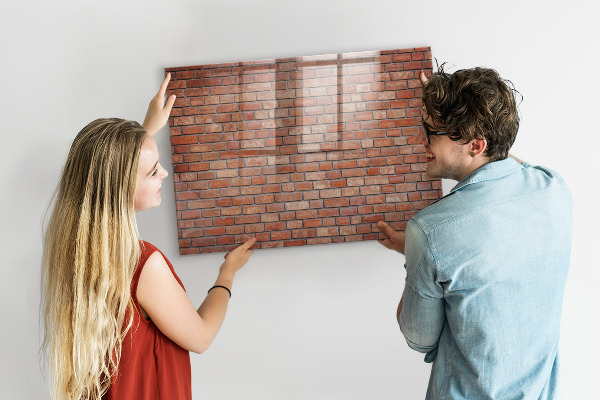 Tableau magnétique effaçable Un tableau d'affichage sur un mur de briques