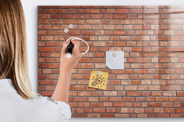 Tableau magnétique effaçable Un tableau d'affichage sur un mur de briques