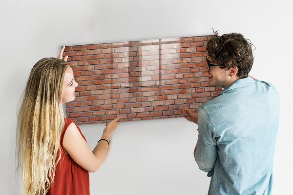 Tableau magnétique effaçable Un tableau d'affichage sur un mur de briques