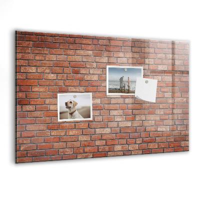 Tableau magnétique effaçable Un tableau d'affichage sur un mur de briques