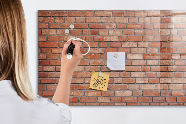 Tableau magnétique effaçable Un tableau d'affichage sur un mur de briques