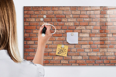 Tableau magnétique effaçable Un tableau d'affichage sur un mur de briques