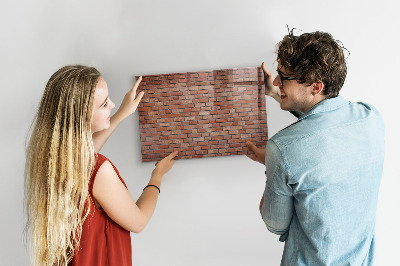 Tableau magnétique effaçable Un tableau d'affichage sur un mur de briques