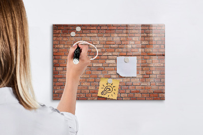 Tableau magnétique effaçable Un tableau d'affichage sur un mur de briques