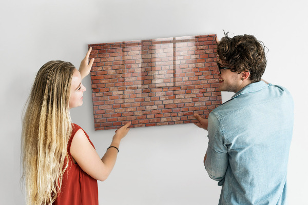 Tableau magnétique effaçable Un tableau d'affichage sur un mur de briques