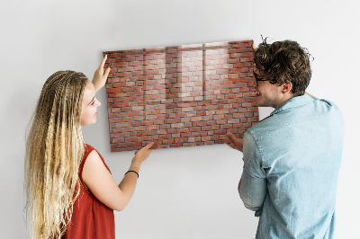 Tableau magnétique effaçable Un tableau d'affichage sur un mur de briques